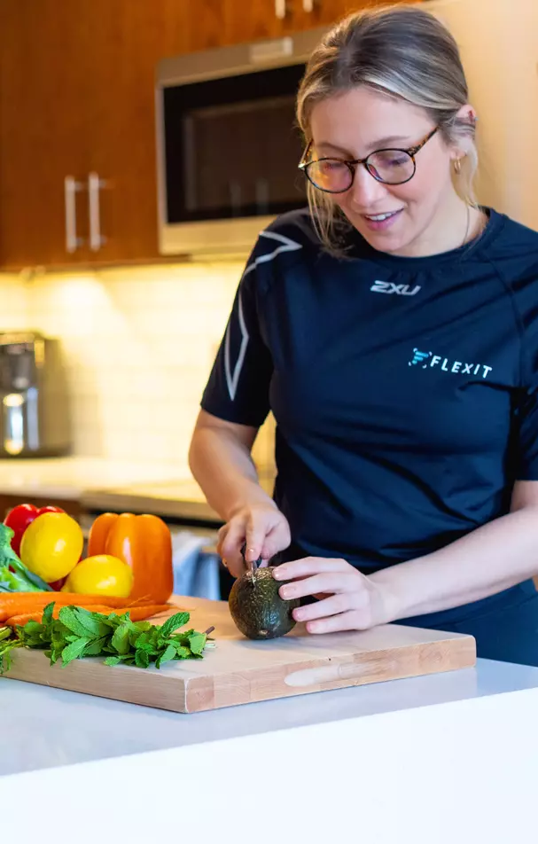 Woman making nutritious salad with vegetables in the kitchen